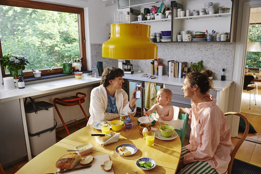 2 personer och ett barn sitter vid frukostbordet